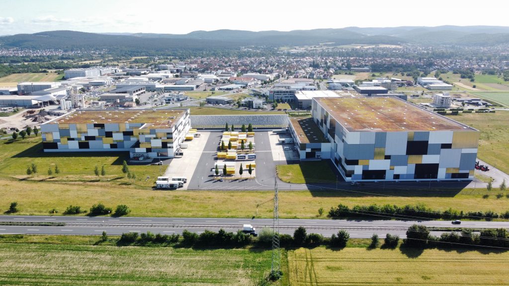 Luftaufnahme des MAINSTACK Logistikzentrums in Niedernberg mit zwei Hallen und Lkw-Höfen an der Autobahn.